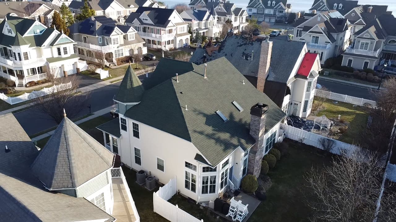 White multi-gable home with a finished dark navy shingle roof